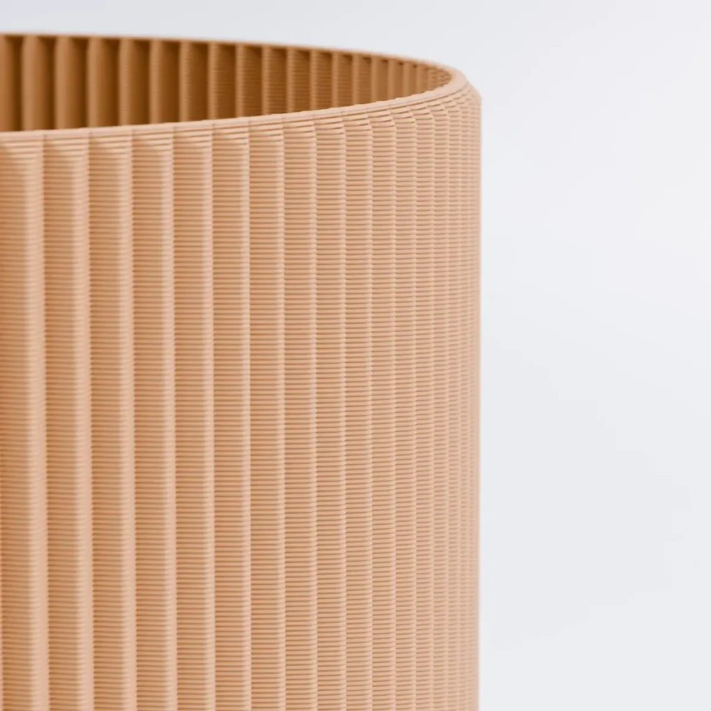 Närbild på kanten och insidan av en 3D-printad kruka i färgen Jord.