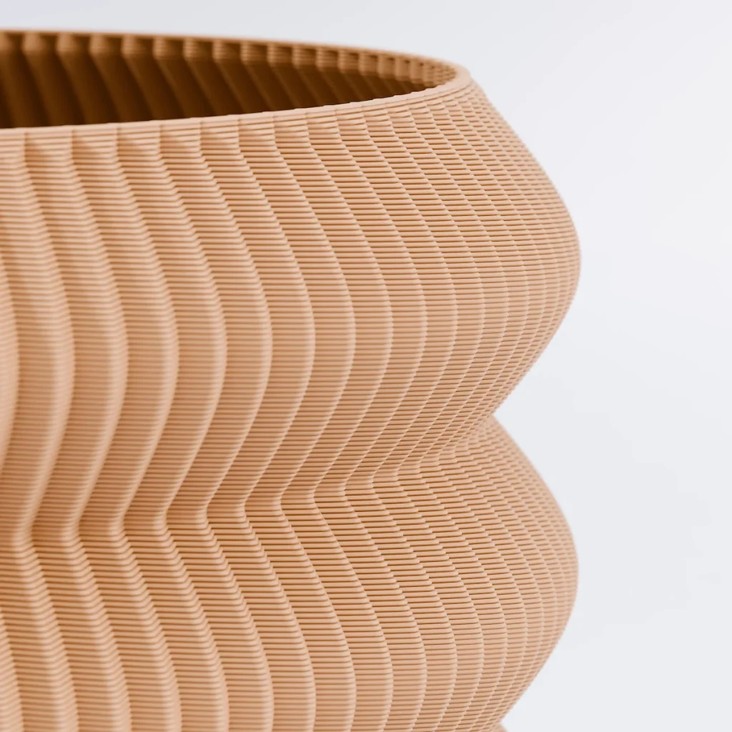 Närbild på kanten och insidan av en 3D-printad kruka i färgen Jord.